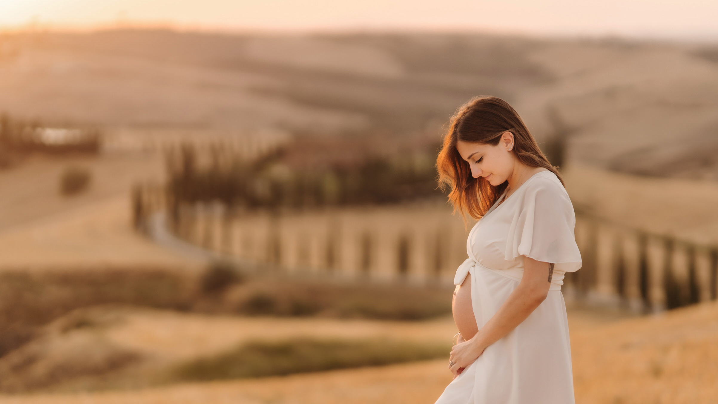 Servizio fotografico di gravidanza, ammirando i panorami delle Crete Senesi durante la loro babymoon